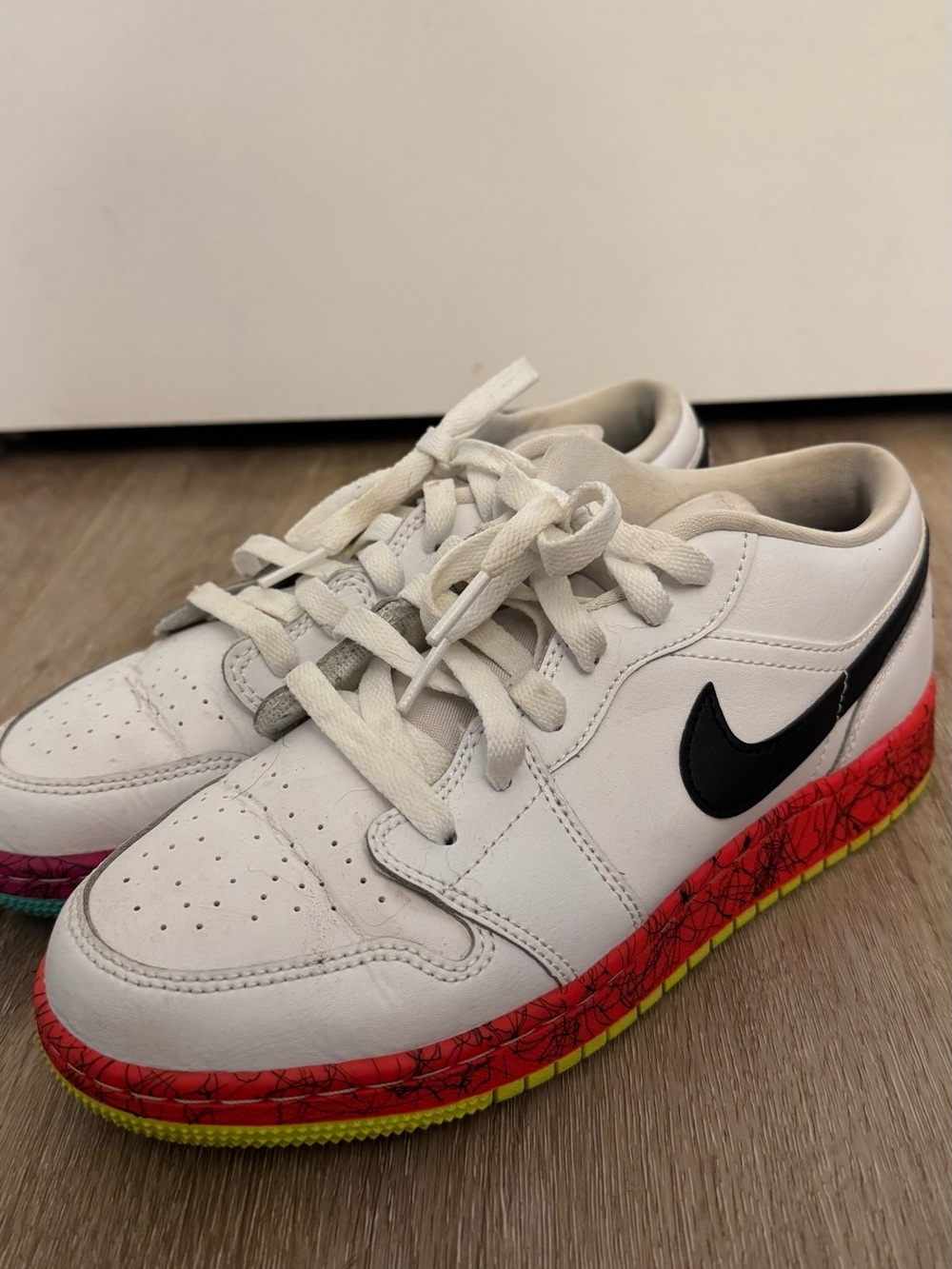 Nike White Kids Low-Top Sneakers with Black Swoosh and Red-Yellow Accent Sole